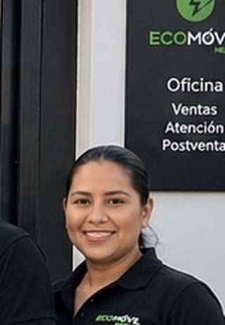 Woman in black ECOMOV uniform smiling at camera in front of company signage