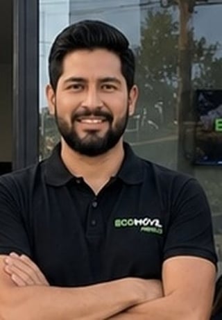 Man with dark hair and beard smiling at camera, wearing black polo shirt with EcoMovl logo, arms crossed