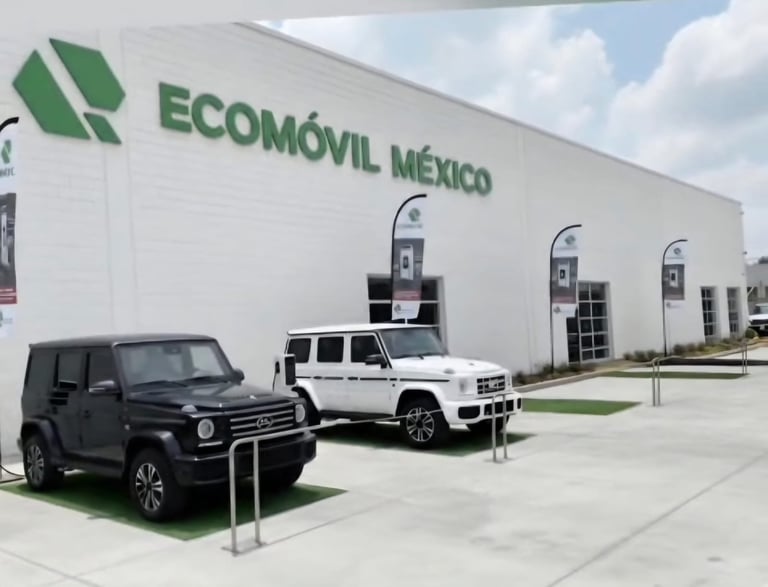 Two electric vehicles charging at an Ecomovil Mexico facility with white building and charging stations